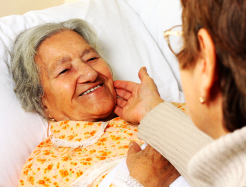 caregiver touching the face of elderly woman