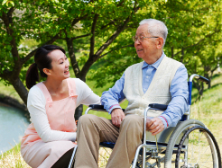 elderly man in wheelchair with caregiver