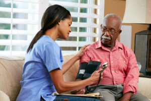 caregiver monitoring blood pressure of the old man